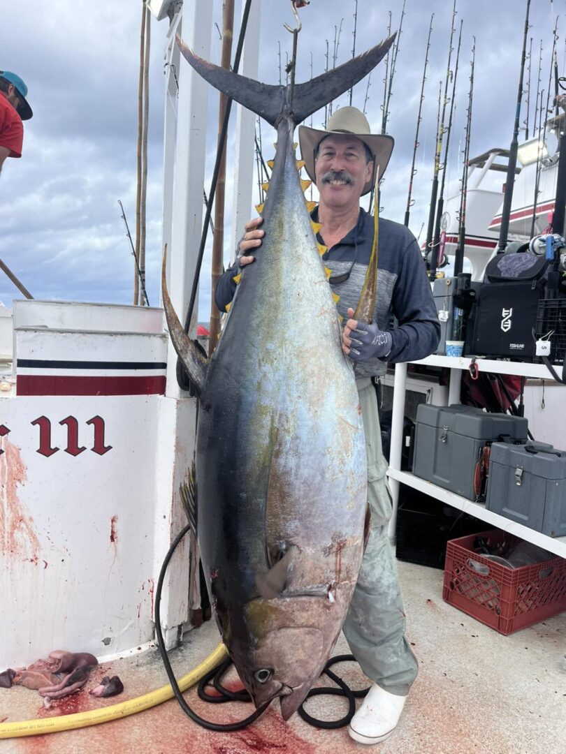 Proud angler displaying huge tuna
